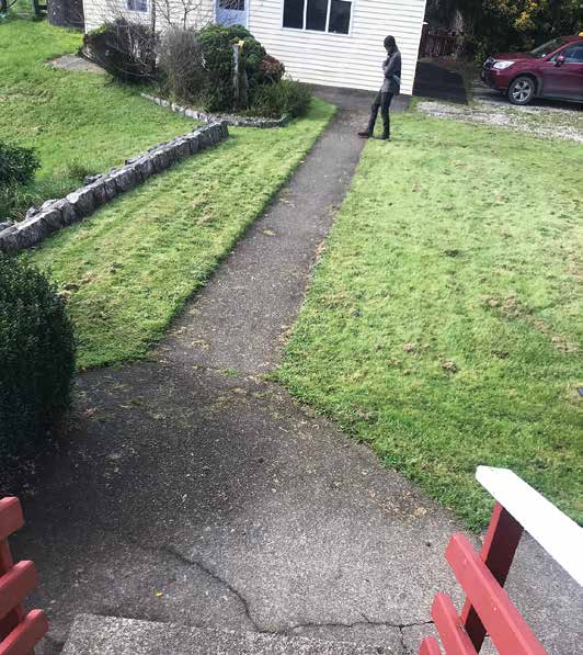 Suspected sighting of Tom Phillips. Image showing man in full balaclava from a distance in a garden.